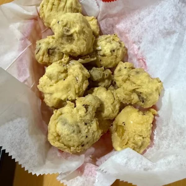 Golden-brown fried mushrooms in a paper-lined basket from Sam's Burger Deli.
