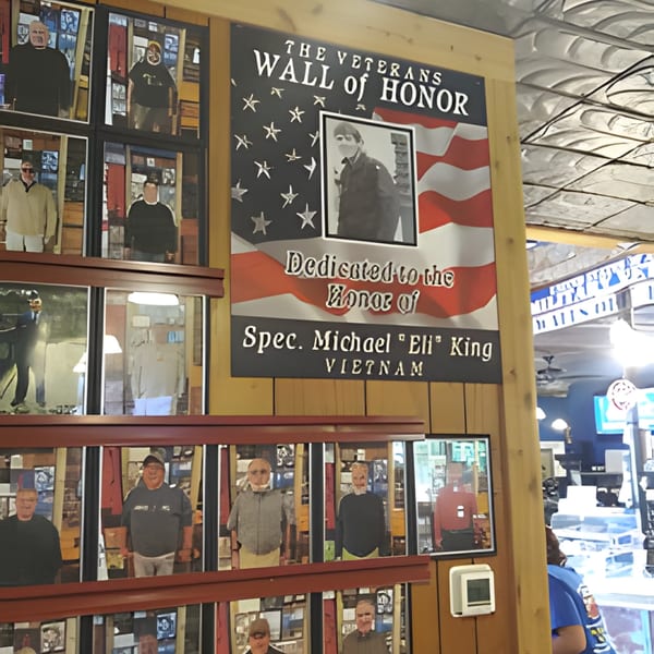 A Veterans Wall of Honor with photos of veterans, including Spec. Michael "Eli" King, in Sam's Burger Deli.